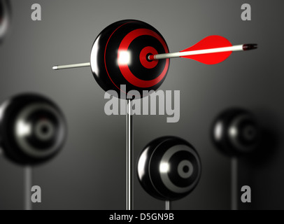 Una freccia rossa di colpire il centro di una sfera target con altri obiettivi di sfocatura intorno, sfondo nero con effetto di luce Foto Stock