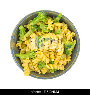 Vista dall'alto di una vecchia ciotola riempita con pasta in una salsa al formaggio con broccoli su uno sfondo bianco. Foto Stock