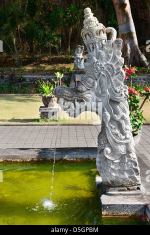 Fontana con il tradizionale design Balinese in pietra immagine drago statua in Goa Lawah Bat tempio nella grotta, Bali, Indonesia Foto Stock