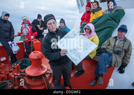 Guida per tour in barca a parlare con i turisti su icebergs, Ilulissat (Jakobshavn), la Groenlandia Foto Stock