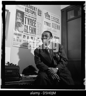 Ritratto di Tyree Glenn, un rinomato trombonista jazz, catturato a New York nel luglio 1947. Glenn era una figura di spicco nell'era delle big band, noto per le sue esibizioni con Duke Ellington e Count Basie. Questa immagine riflette la sua presenza iconica nella scena jazz durante un periodo di trasformazione nella storia della musica americana. Foto Stock
