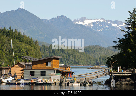 Isola di Vancouver, Tofino. Le case galleggianti di fronte montagne di Strathcona Provincial Park. Foto Stock