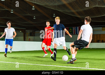 Uomini Squadra giocare a calcio o calcio indoor e cercando di segnare un gol Foto Stock