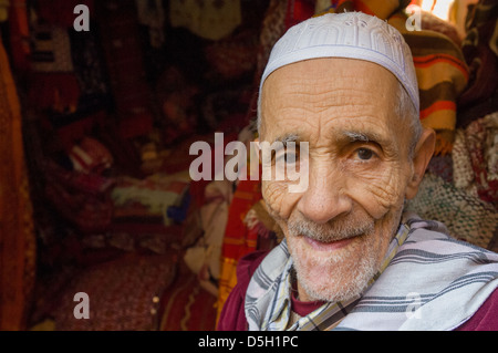 Il vecchio uomo marocchino lavora in una fase di stallo nel souk di Marrakech, Marocco Foto Stock