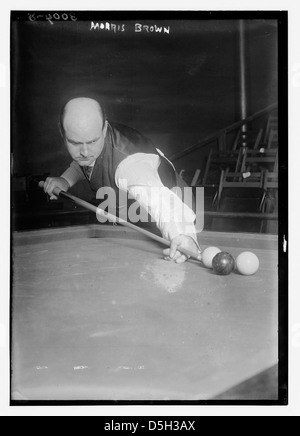 Una fotografia di Morris D. Brown che gioca a biliardo, con una pallina e la sua concentrazione sul gioco. Morris viene visto con una testa calva e un segnale in piscina in mano. Foto Stock