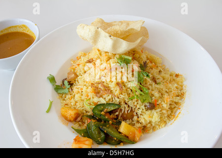 Indian Nasi Briyani piatto di riso con salsa al curry verdure sott'olio e crackers piatto locale Foto Stock