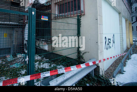 La polizia ha una cordata off "Casa di economia" con nastro di barriera, il codice "RAZ' e la falce e martello sono spruzzati su una delle sue pareti a Berlino, Germania, 04 febbraio 2010. Come la polizia comunicati, una cartuccia di gas che aveva fatto esplodere sul retro dell'edificio nella notte del 03 febbraio e ha provocato lievi danni di fuliggine. I trasgressori sono presumibilmente ala sinistra gli estremisti; uno federale Foto Stock