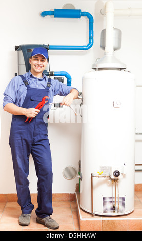 Sorridendo Il tecnico di riparazione di una caldaia Foto Stock