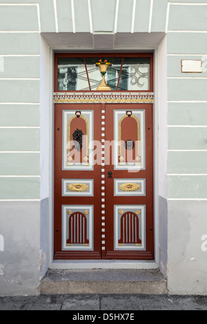 Rosso antico porta in legno con elementi di decorazione. Tallinn, Estonia Foto Stock