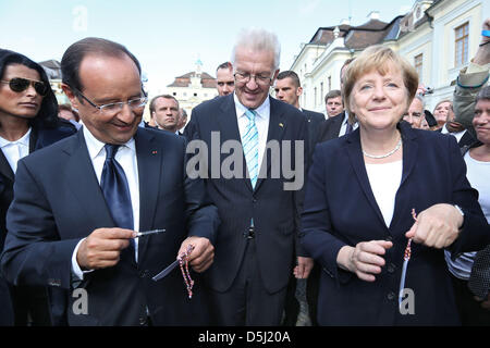 Il Presidente francese Francois Hollande (l) e il Cancelliere tedesco Angela Merkel (r) nonché il primo ministro del Baden-Wuertemberg Winfried Kretschmann (m) assistere ad una cerimonia commemorativa presso il castello di Ludwigsburg, Germania, 22 settembre 2012. La cerimonia commemora il cinquantesimo giubileo del discorso sulla gioventù dell ex Presidente francese Charles de Gaulle sul castello di Ludwigsburg in 196 Foto Stock