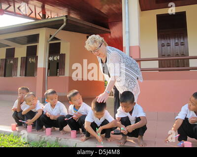 Gerlinde Engel è raffigurato con i suoi alunni nella scuola nel villaggio Sikeud, Laos, 05 novembre 2012. La spazzolatura dei denti e sport al mattino sono parti del rituale giornaliero presso la scuola dove Gerlinde Engel corre una nave stretta. Engel utilizzato per avviare e gestire le fabbriche tessili in tutto il mondo per anni. Il suo ultimo arresto era in Laos, dove lei ha ora deciso di rimanere e trovato un s Foto Stock