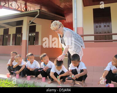 Gerlinde Engel è raffigurato con gli alunni di una scuola in Sikeud, Laos, 05 novembre 2012. Engel fondato e gestito fabbriche tessili in tutto il mondo per molti anni. In questi giorni, Gerlinde Engel vive in Laos e si prende cura di più di mille bambini presso la scuola di Sikeud. Foto: Christiane Oelrich Foto Stock