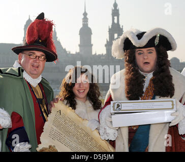 Lo Stollen ragazza Cynthia Brozek (C), Agosto il forte ritratto di Steffen urbano (R) e il buffone di corte Froelich, Matthias Schanzenbach, (L) presente il gigante lo Stollen decreto sulle rive del fiume Elba a Dresda, Germania, 15 novembre 2012. Tre settimane prima del XIX festival stollen, inizia il lavoro sui tre ton stollen gigante. Foto. Matthias Hiekel Foto Stock