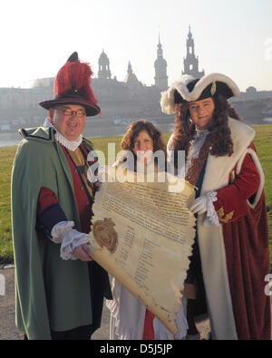 Lo Stollen ragazza Cynthia Brozek (C), Agosto il forte ritratto di Steffen urbano (R) e il buffone di corte Froelich, Matthias Schanzenbach, (L) presente il gigante lo Stollen decreto sulle rive del fiume Elba a Dresda, Germania, 15 novembre 2012. Tre settimane prima del XIX festival stollen, inizia il lavoro sui tre ton stollen gigante. Foto. Matthias Hiekel Foto Stock