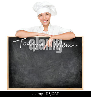 Femmina giovane cuoco o chef mostra menu segno blackboard scritto del Menu Oggi isolato su sfondo bianco Foto Stock