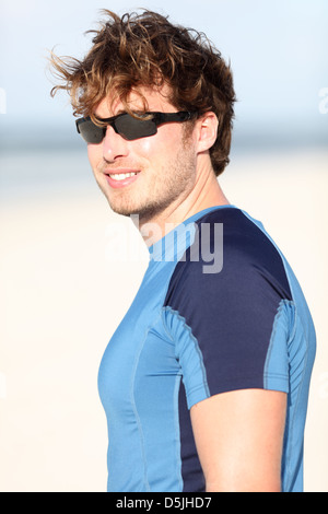 Sportivo caucasico giovane uomo sorridente felice dopo outdoor esecuzione di allenamento sulla spiaggia Foto Stock