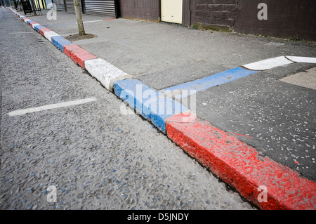 Rosso, bianco e blu cordoli in fila di sabbia, Belfast Foto Stock