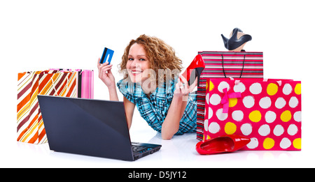 Felice shopping giovane donna con laptop, borse per lo shopping in possesso di una carta di credito e un colore rosso pattino - isolato Foto Stock