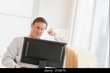 Lavoratore di ufficio il tifo nella parte anteriore del computer Foto Stock