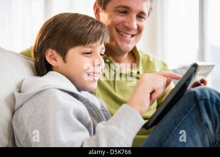 Padre e figlio (8-9) utilizzando la tavoletta digitale Foto Stock