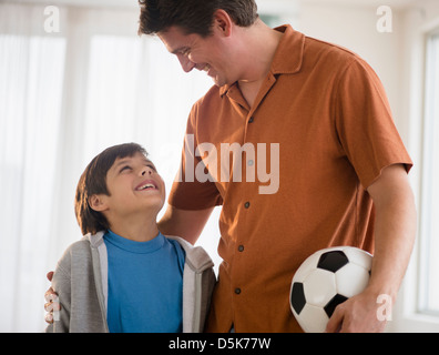 Padre e figlio (8-9) con pallone da calcio Foto Stock