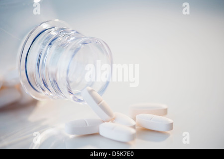 Studio shot di bianco pillole fuoriuscita della bottiglia Foto Stock