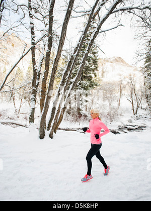 Stati Uniti d'America, Utah, Salt Lake City, Donna jogging nel bosco invernale Foto Stock