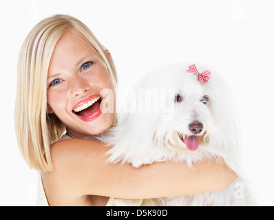 Studio Shot, Ritratto di giovane donna azienda cane Foto Stock