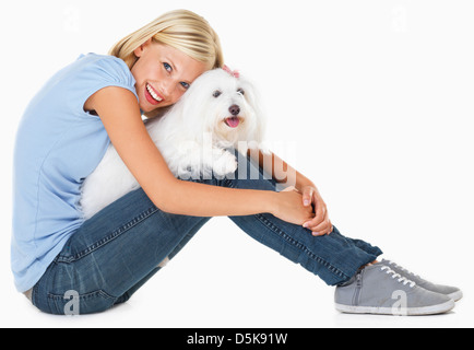 Studio Shot, Ritratto di giovane donna seduta e tenendo il cane Foto Stock