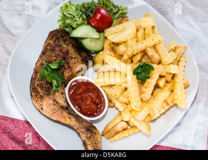Grigliata di cosce di pollo con patatine e salsa Foto Stock