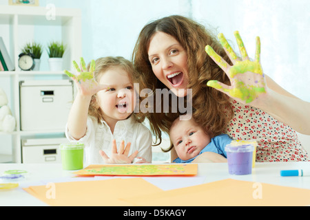 Ritratto di una famiglia felice avendo divertimento pittura con palme e dita Foto Stock