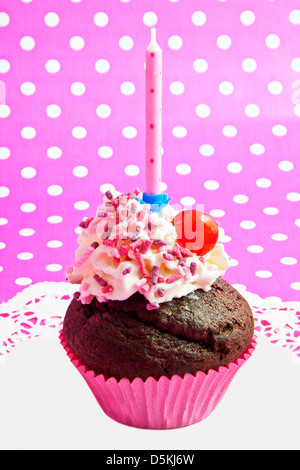 Compleanno cupcake isolato su una rosa macchie bianche sullo sfondo Foto Stock