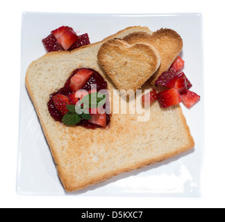 Toast con cuori su una piastra isolata su sfondo bianco Foto Stock