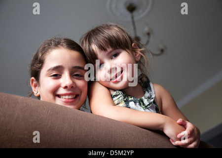 Due ragazze (cugini) appoggiata sopra il lettino e sorridente Foto Stock