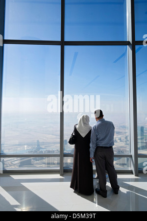 I turisti che si affacciava su Dubai da in alto a piattaforma di osservazione in Burj Khalifa la struttura più alto del mondo a Dubai Uni Foto Stock