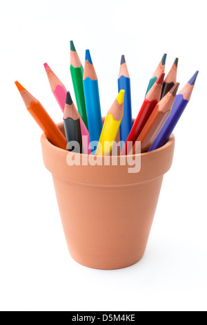 Forniture di disegno: colori assortiti matite in vaso di ceramica, isolato su sfondo bianco Foto Stock