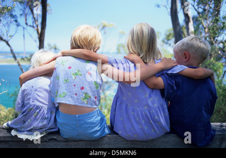 Famiglia, Bambini 4 bambini (3 ragazze/1 boy) in una fila holding alle spalle, vista posteriore, capelli biondi da 2-8 anni. Foto Stock