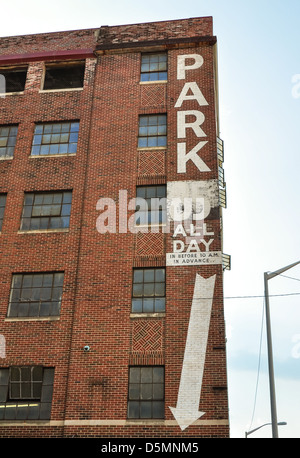 Il vecchio edificio in mattoni che indica parcheggio Foto Stock