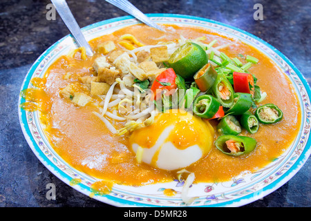 Il malese Mee Rebus Noodle piatto guarnito con taglio Peperoncino cinese Tofu Sedano e uovo sodo Foto Stock