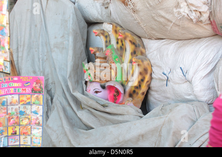 Un idolo del dio indù, Ganesh, si nasconde dietro i sacchi nel Gulbai Tekra località di artigiani, Ahmedabad, Gujarat, India. Foto Stock
