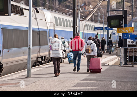 Passeggeri a piedi su una piattaforma della stazione verso il treno - Bourg Saint Marice, Francia Foto Stock