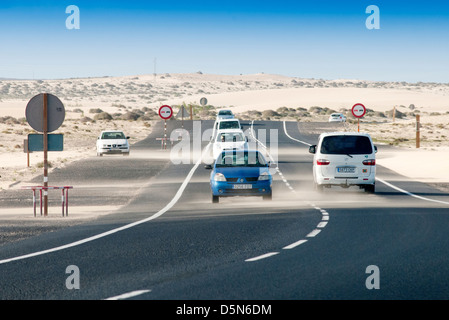 Soffiatura di sabbia attraverso la strada in Fuerteventura Foto Stock