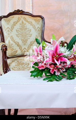 Configurazione Studio di sedia e tavolo da caffè con fiori di colore rosa sulla parte superiore Foto Stock