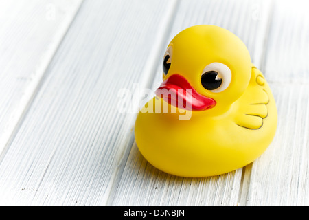 Bagno di colore giallo di anatra bianco sul tavolo di legno Foto Stock