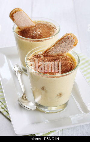 Tradizionale dolce italiano tiramisù in un bicchiere su sfondo di legno Foto Stock