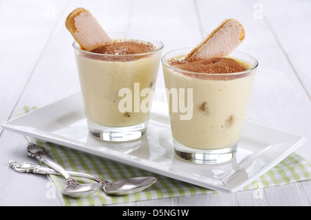 Tradizionale dolce italiano tiramisù in un bicchiere su sfondo di legno Foto Stock