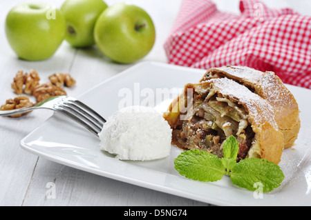 Strudel di mele su un piatto di portata con mele fresche e i dadi Foto Stock