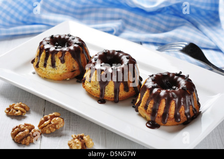 Torta con fuso chokolate ciliegina sul piatto bianco su sfondo di legno Foto Stock