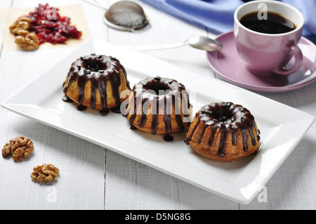 Torta con fuso chokolate ciliegina sul piatto bianco su sfondo di legno Foto Stock