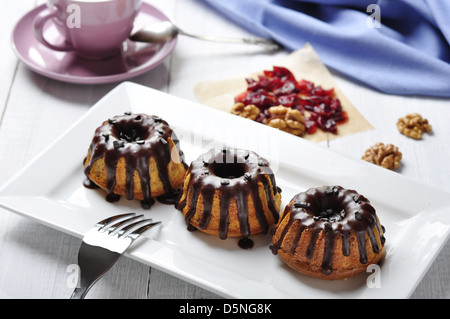 Torta con fuso chokolate ciliegina sul piatto bianco su sfondo di legno Foto Stock